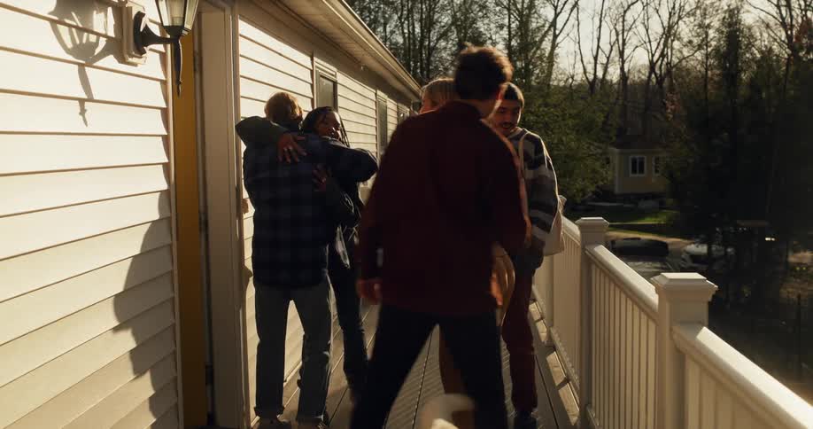 Group of friends greeting each other and entering the house
