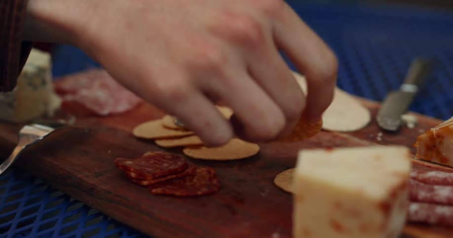 A person picks up a slice of meat to eat