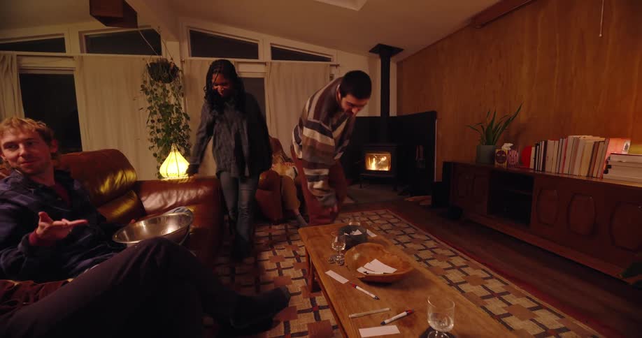 Group of friends in the living room talking and playing