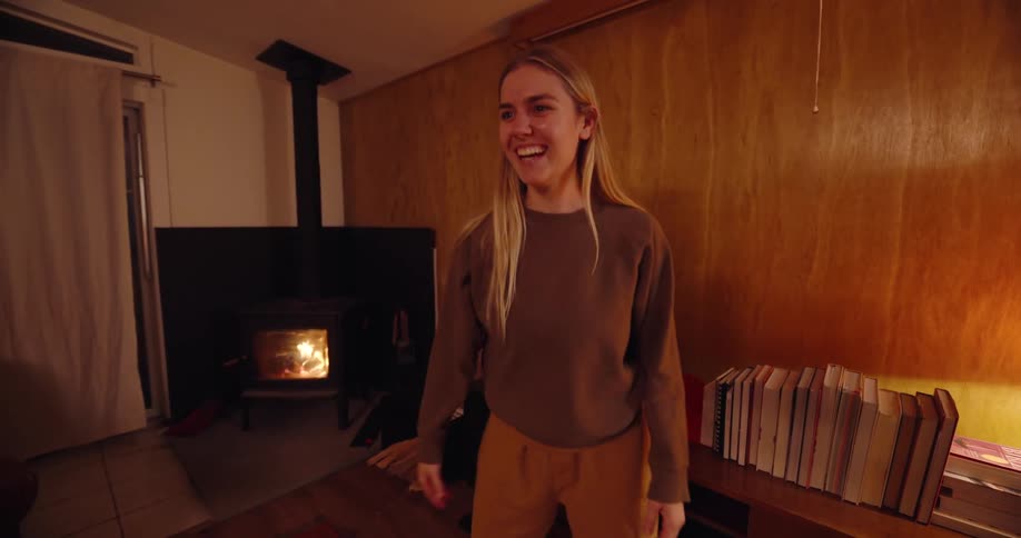 Woman demonstrates a word in front of a group of friends as they play charades in a living room
