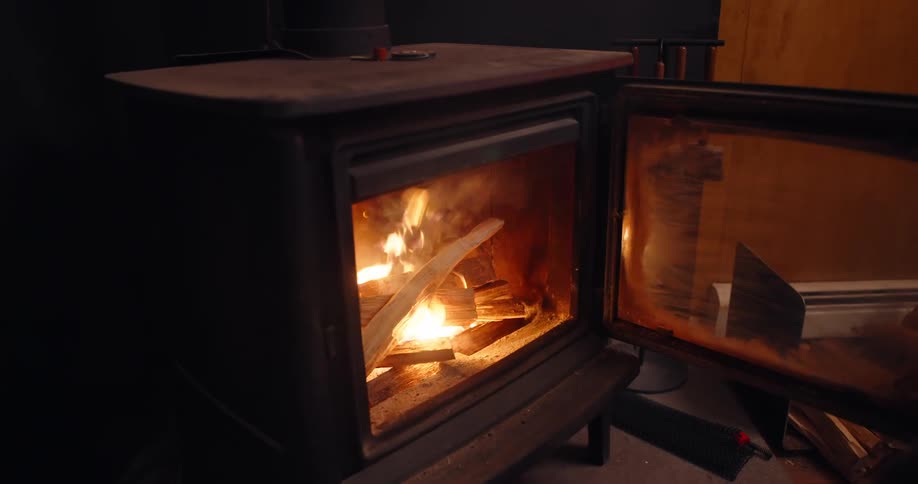 A man adds more wood to the fireplace