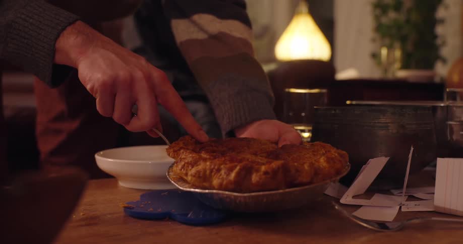 A persons hand taking a piece of food and placing it in a white bowl