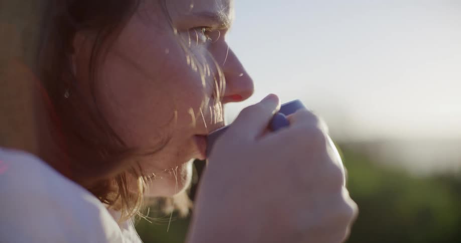A woman is drinking coffee on a sunny day