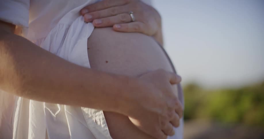 A pregnant woman is rubbing her stomach