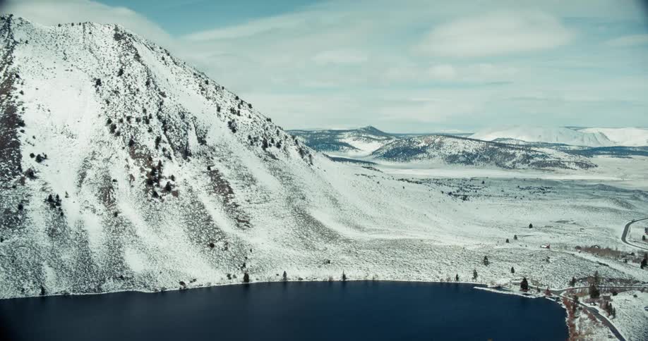 A lake sits next to the snow covered mountain
