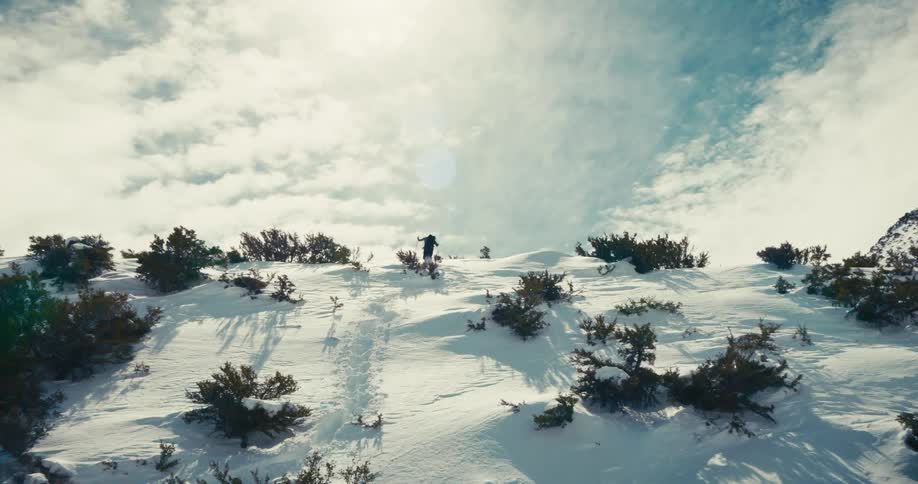 A man is hiking up the snow covered mountain