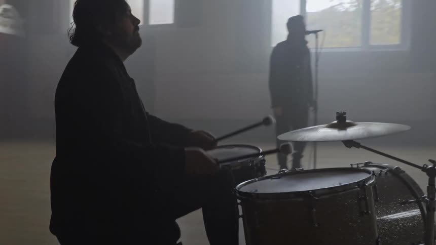 The band is performing together near the stage
