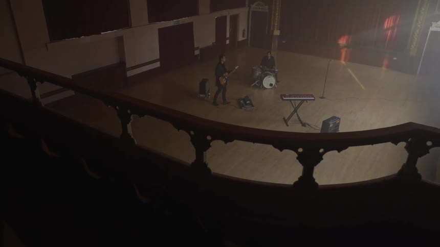 Guitarist and a drummer in a rehearsal in the hall