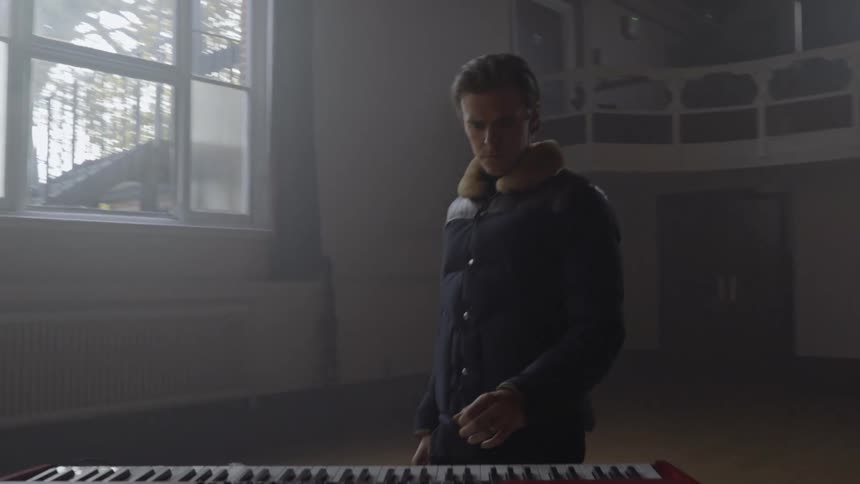 A man walks up and begins playing music on the keyboard