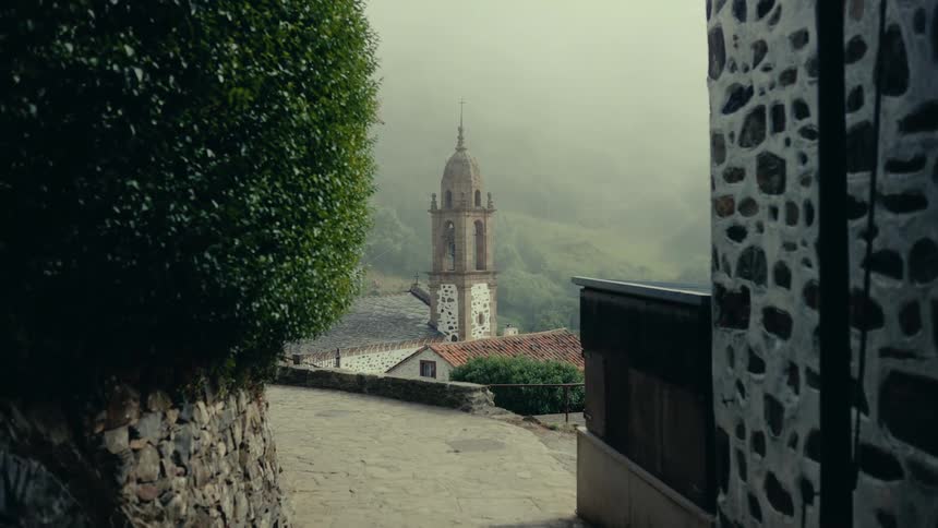 Church with a tower in the background and mountains