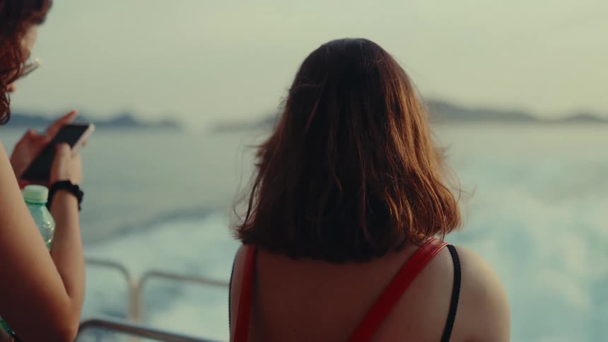 Two women are riding on the motorboat