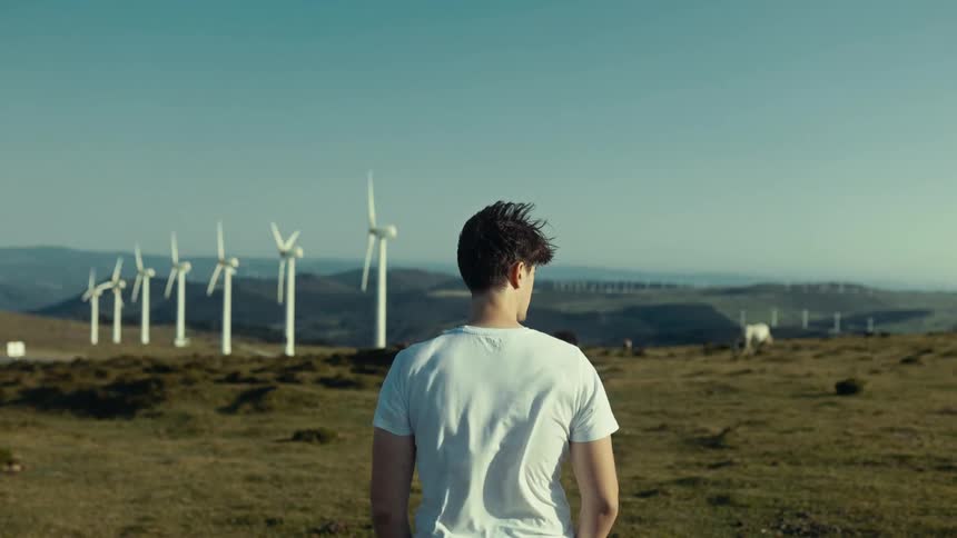 Man in an outdoor field with wind power platforms