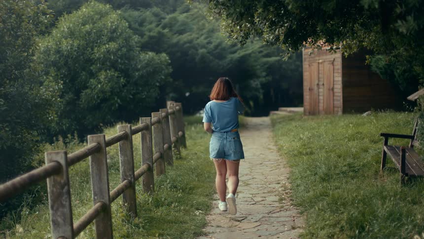 Woman walking along a wooded trail
