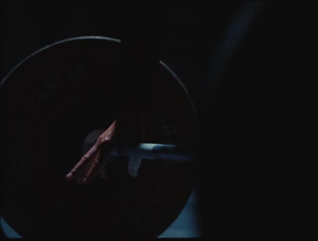 A closeup shows a hand gripping a barbell in a dimly lit gym highlighting strength and focus