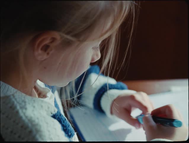 Little blonde girl writing
