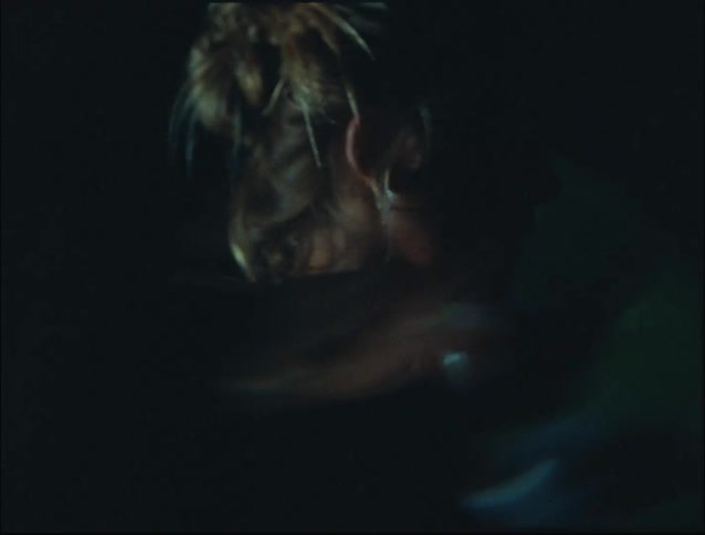 Woman lifts weights in a dark area lit by flashes of light