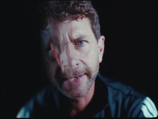 Flashing light illuminates a man yelling while in a dark area