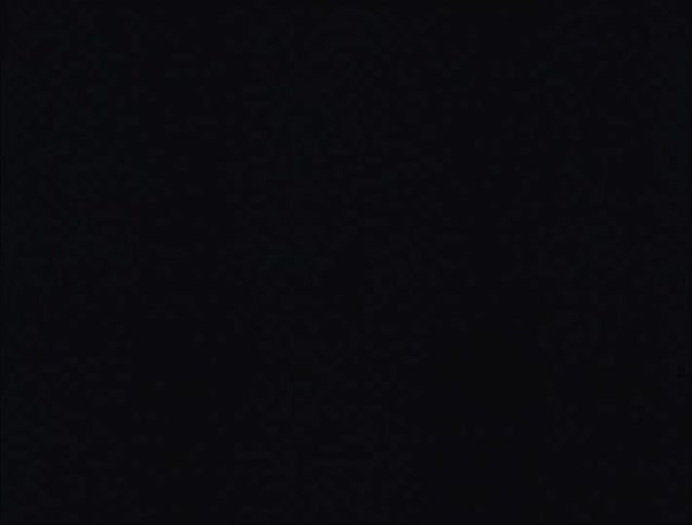 A dark room with a white curtain and a bed and the lights are flashing