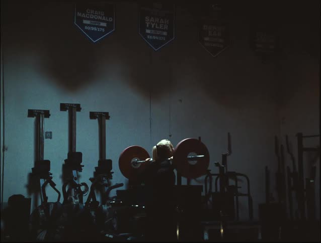 A woman at the gym doing squats with weights