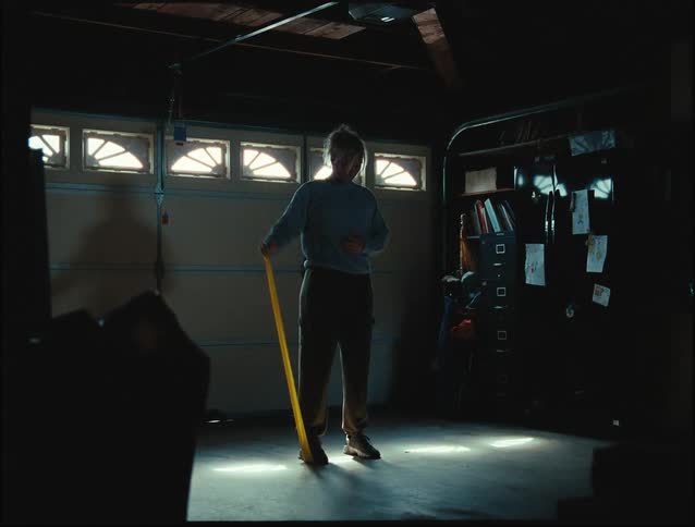 A woman in a garage doing exercises with a resistance band