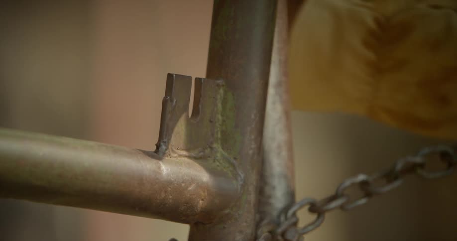 A person unwraps a chain from a pole