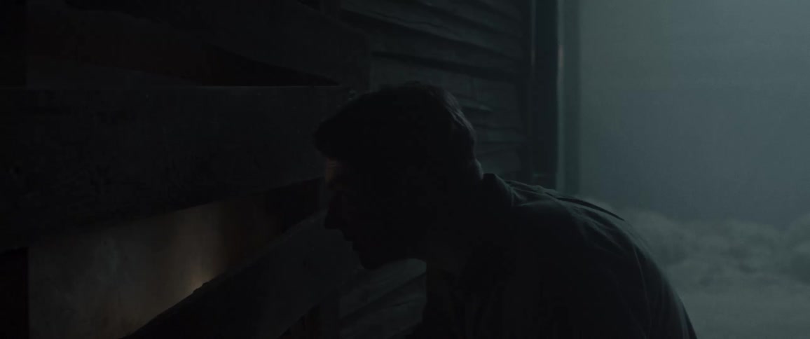 Two men with flashlight in foggy night environment next to wooden house
