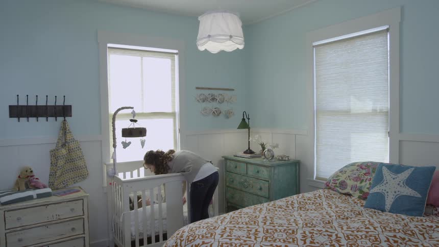 Woman carries baby to a crib