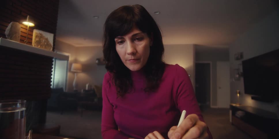 A woman uses a stylus on her tablet at her desk