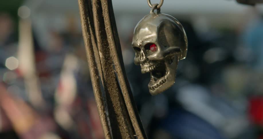 Leather straps hang near a metal skull