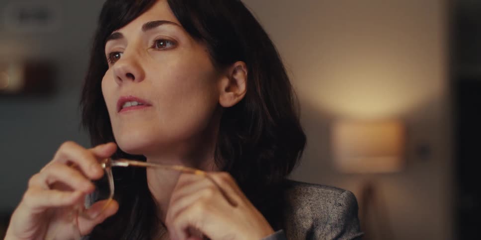 Woman takes off the glasses she holds in front of her face