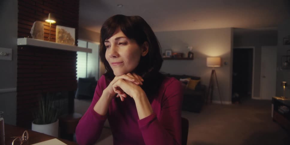 A woman smiles as she thinks about something