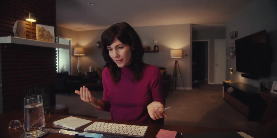 A woman talks while using her tablet