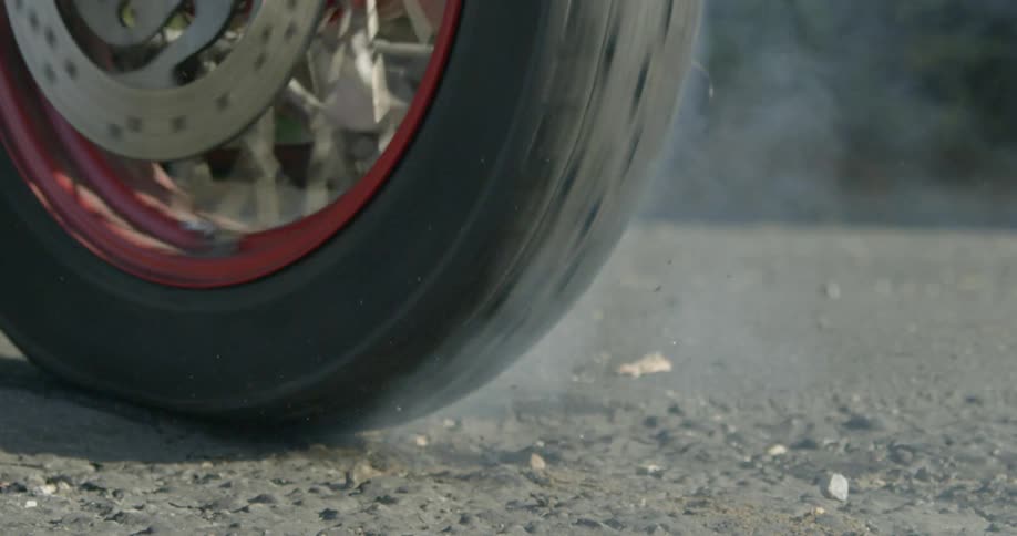 A motorcycle tire peels out on the gravel