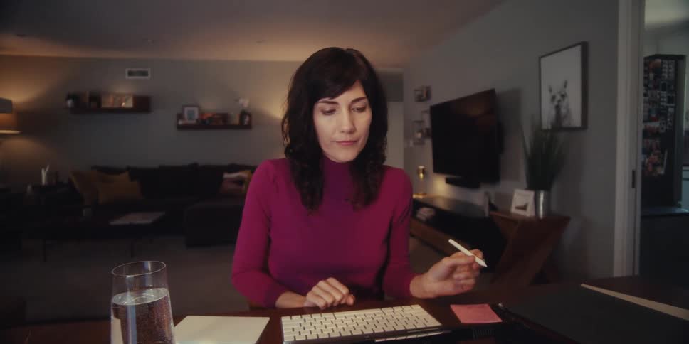 A woman works at a table off a tablet