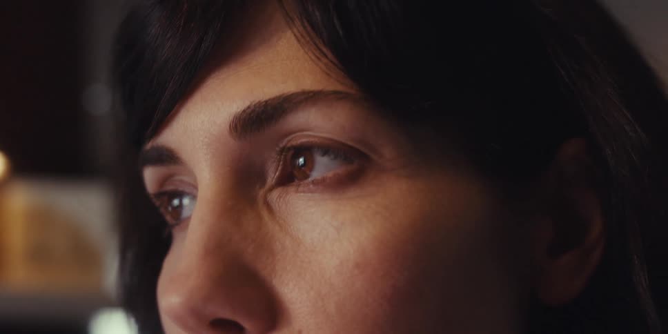 Woman putting a pen in her mouth and looking thoughtful
