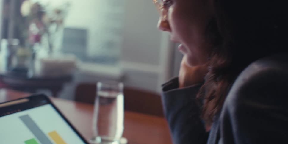 Woman with glasses working in front of a tablet