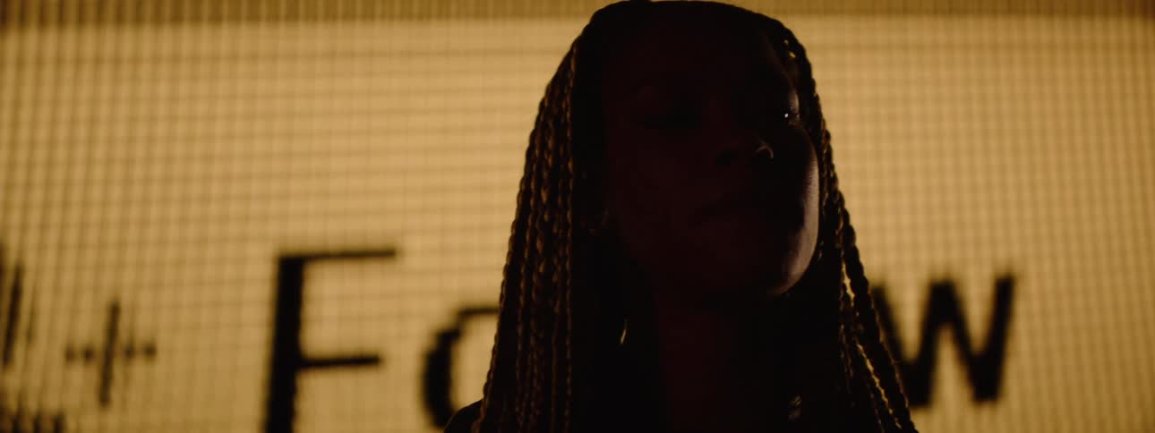 A woman checks her phone as a projector flashes an image on her