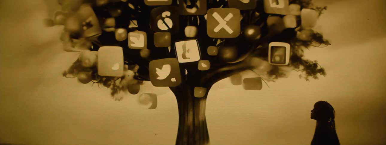 Animated image contains a female looking up at a tree covered in symbols