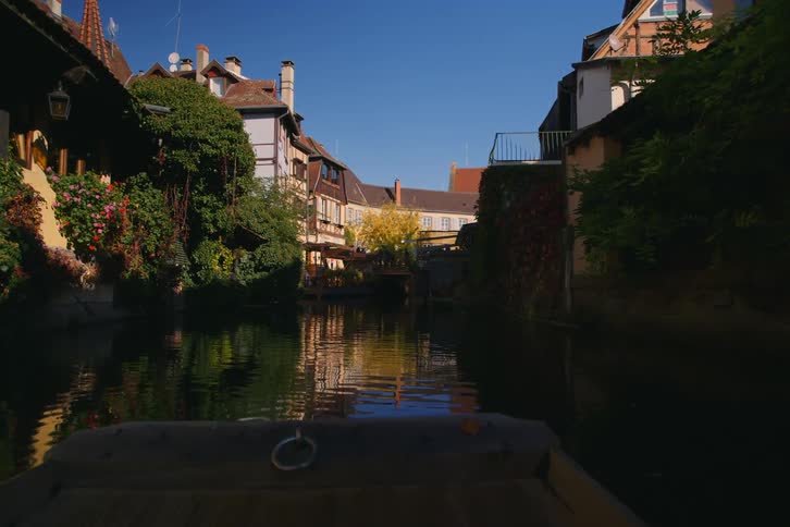 The small boat travels down the canal in town