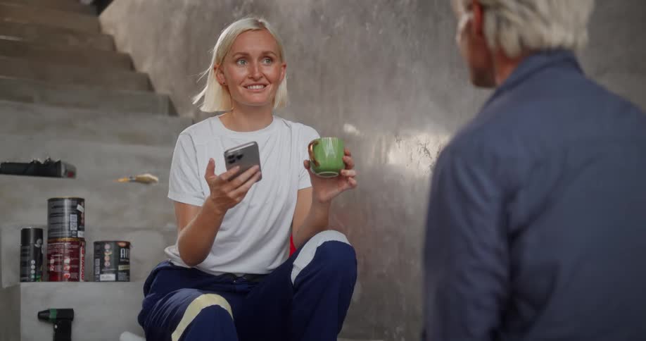 Man and woman talking with paint cans in the background