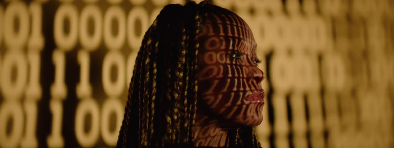 The projection is flashing changing numbers on the womans face