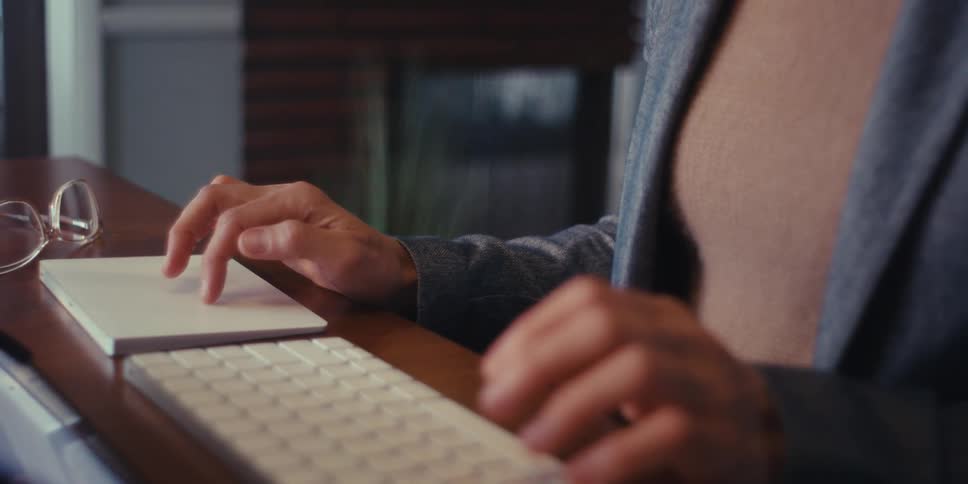 A woman uses a keyboard and tablet at home