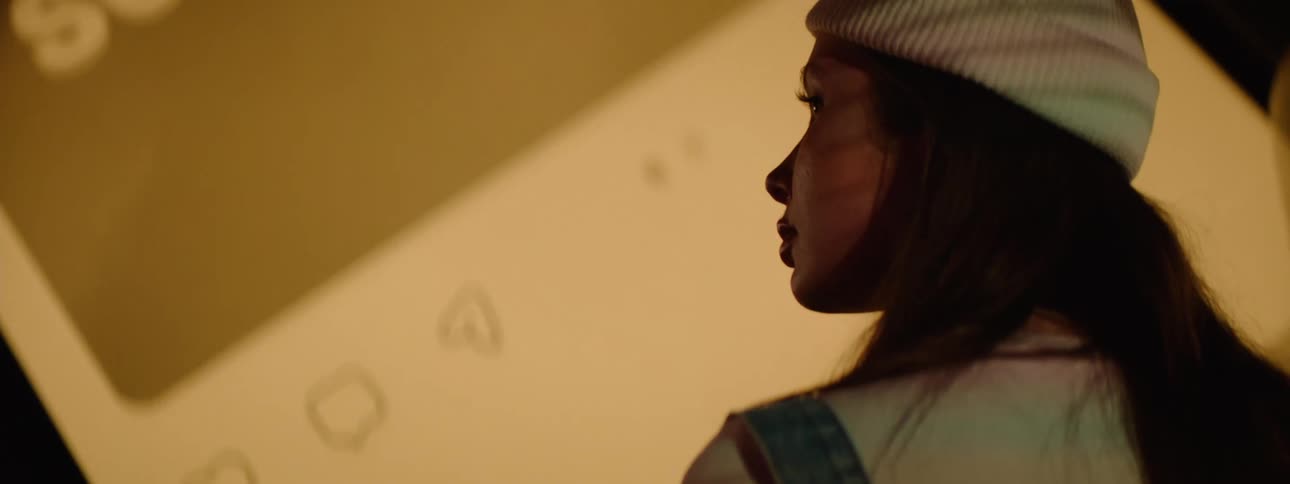 A footage of a lady standing in front of a big screen