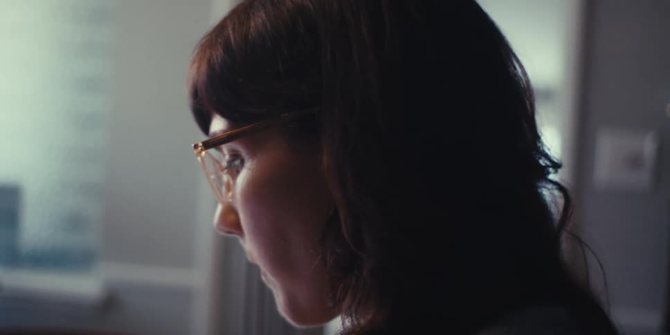 Woman working from home analyzing bar charts on a tablet and taking notes in a notepad
