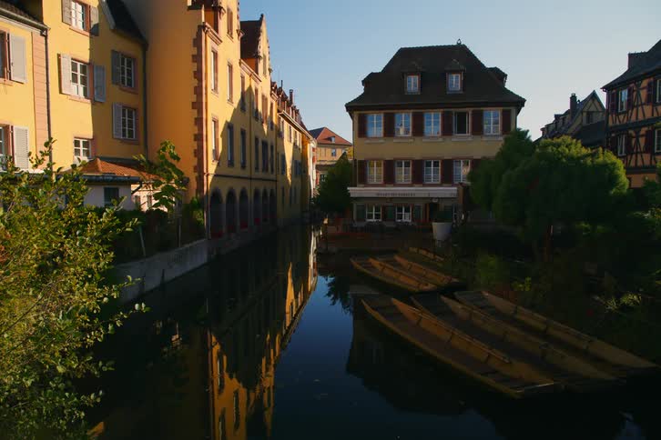 Houses in the middle of a river with canoes on the water