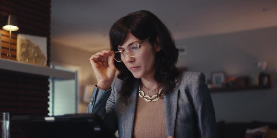 A woman looks at and works at her computer