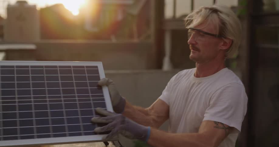 A man placing a solar panel on a concrete surface