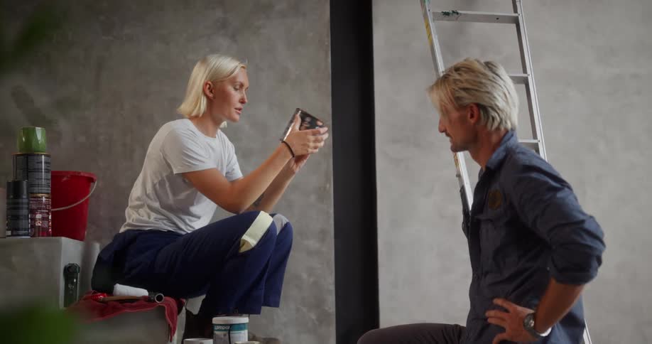 A woman shows a container to a man