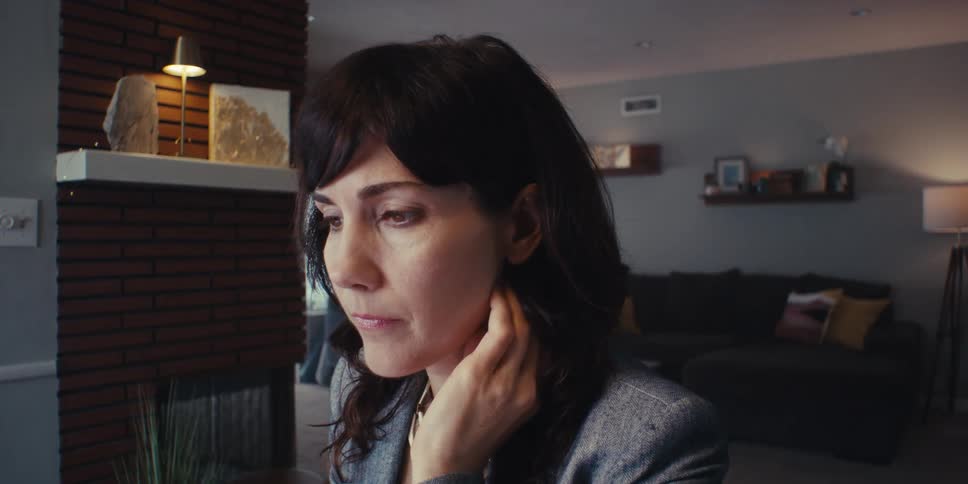Woman sitting in a room of the house thinking