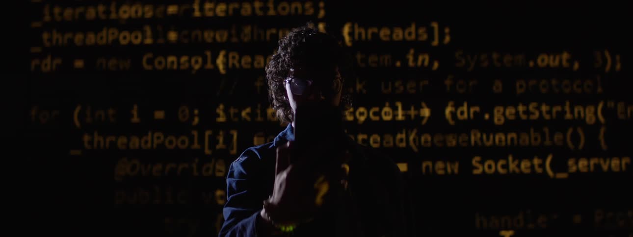 Person in front of a screen displaying source codes